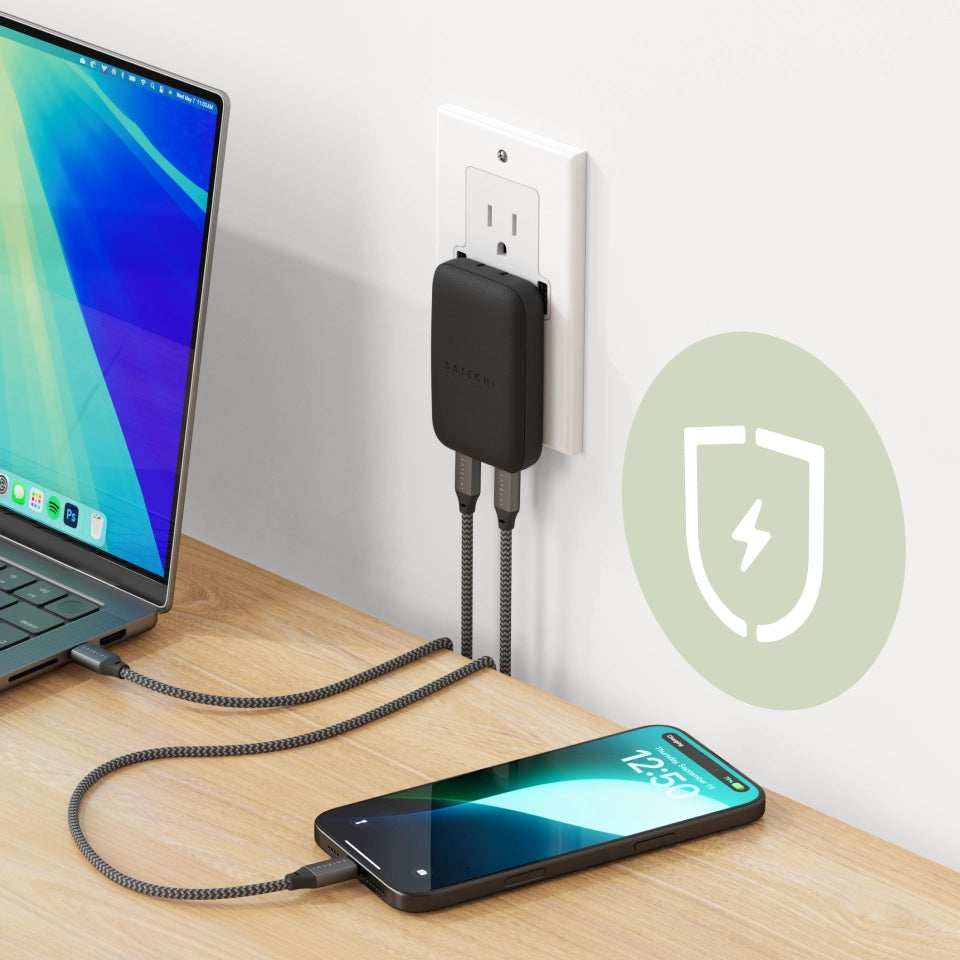 OntheGo™ 67W Slim Wall Charger plugged into wall and charging both an iPhone and MacBook.