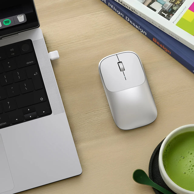 A Slim Ex Wireless Mouse connected to a MacBook with its 2.4GHz receiver for effortless switching.