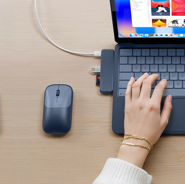 Satechi EX wireless mouse in indigo next to an Indigo MacBook Neo, with Satechi USB-C Snap Hub attached, holding a flash drive and microSD card.