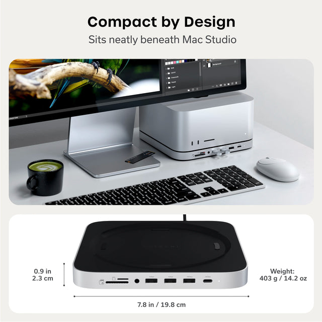 “Compact by Design. Sits neatly beneath Mac Studio.” Top: a white desk setup with a silver Mac Studio on the Satechi Stand & Hub For Mac Studio M5 With NVMe SSD Enclosure, under a monitor showing a photo of a green parrot open in photo editing software. Two USB flash drives are plugged into the front ports. A loose NVMe SSD sits on the monitor stand, and a white wireless mouse, a black and silver keyboard, and a black mug of matcha latte are on the desk. Bottom: the stand and hub on its own, showing its bla