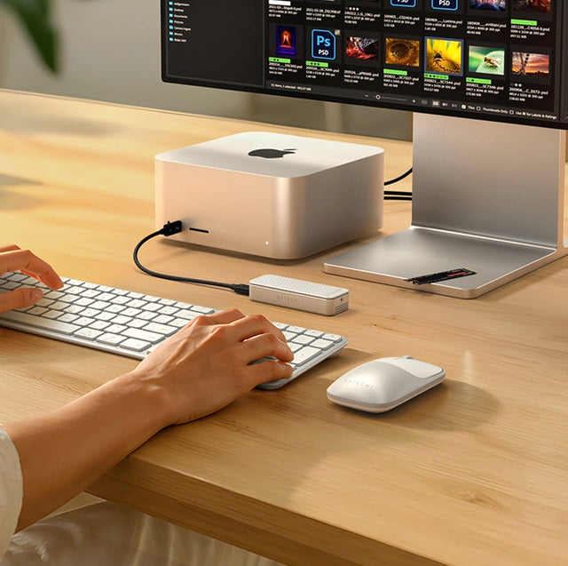 Satechi DotDisk™ 80Gbps SSD Enclosure connected to a Mac Studio on a desk, with a person using a white keyboard and Satechi EX mouse.