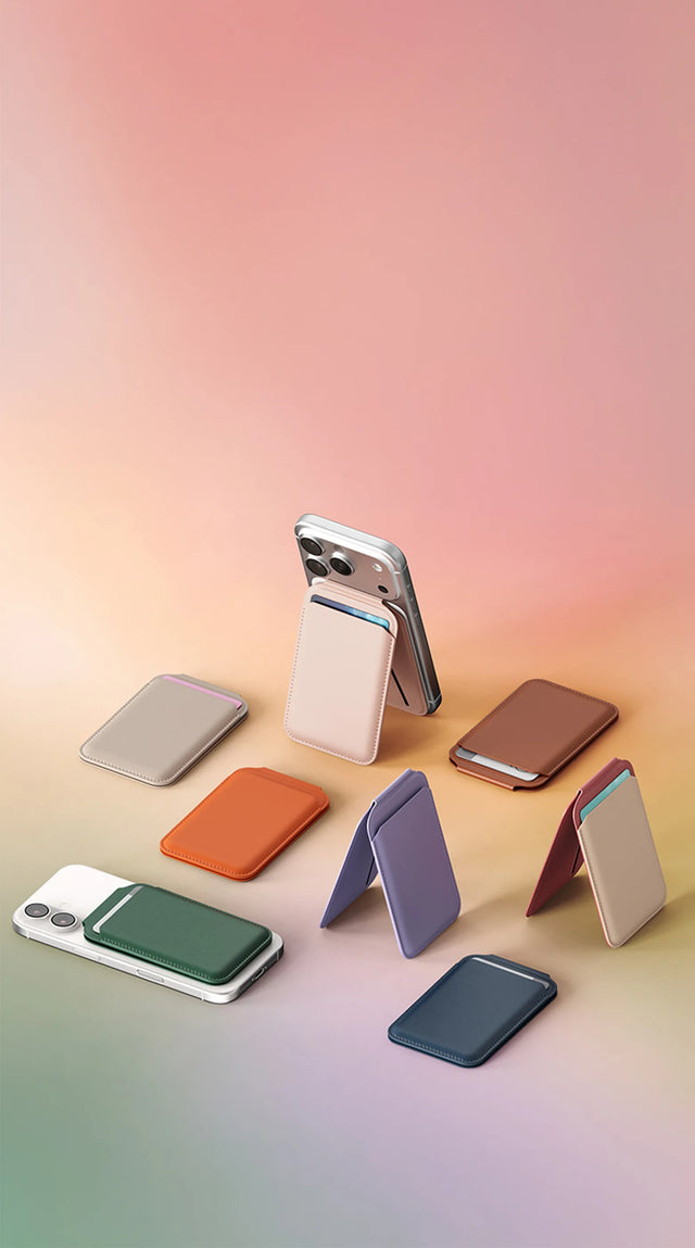 Vegan-Leather Magnetic Wallet Stand collection displayed with iPhones featuring slim cardholder design and foldable stand function. Multiple colors shown including Desert Rose, Orange, Taupe, Purple, Forest Green, Light Blue, Aqua, Coral Pink, Black, Dark Blue, and Brown, arranged on a soft gradient background to highlight texture, magnetic attachment, and hands-free viewing angles.