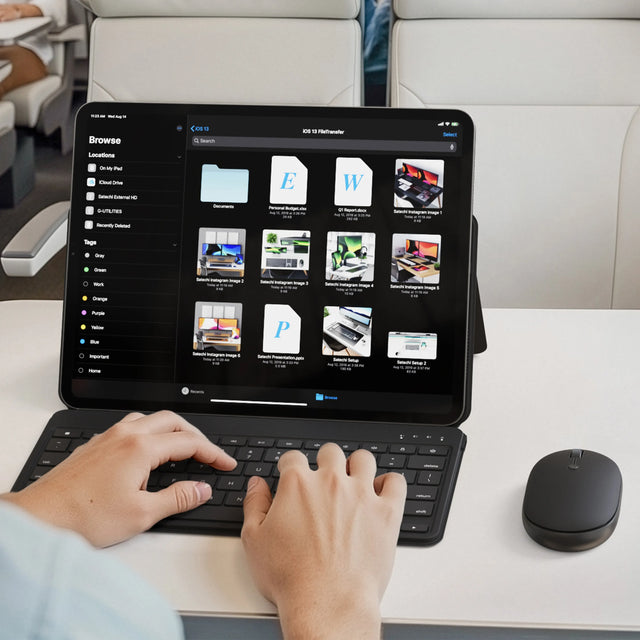 A person using the Satechi OntheGo™ Bluetooth Keyboard with Stand and Bluetooth Mouse to work on their iPad on a train.