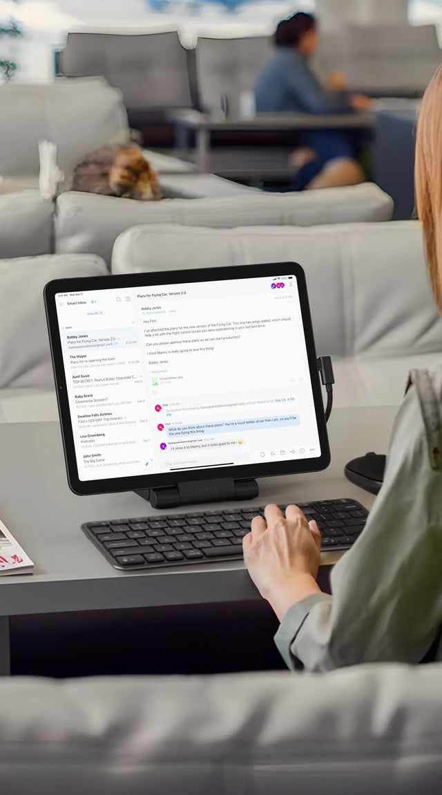 Satechi OntheGo Foldable Stand Hub holding an iPad Air M4 displaying a project management app, paired with a Satechi wireless keyboard, on a modern desk with a coffee cup and magazine — showcasing a complete Satechi productivity workspace setup.
