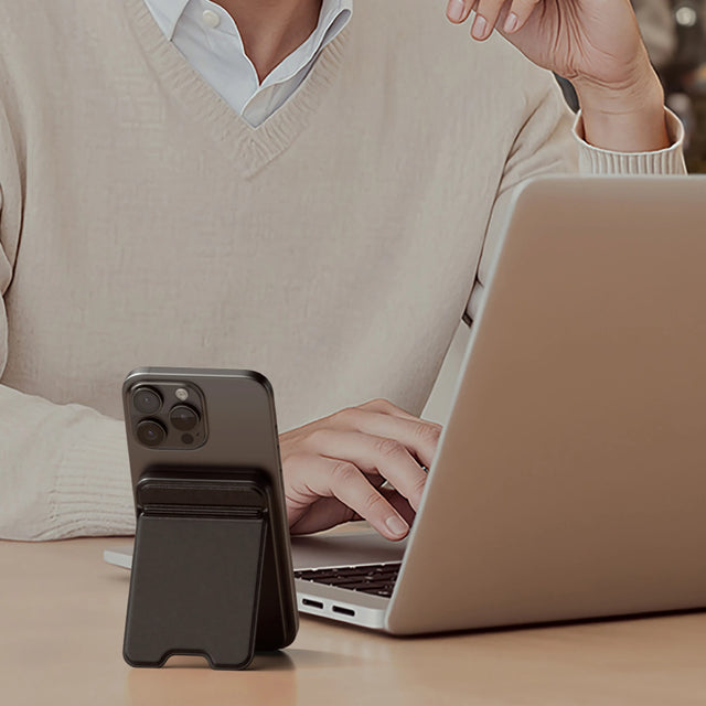 Внешний аккумулятор Satechi OntheGo Power Bank 5K, на котором iPhone установлен вертикально рядом с ноутбуком, демонстрирует свою магнитную подставку для работы без помощи рук.