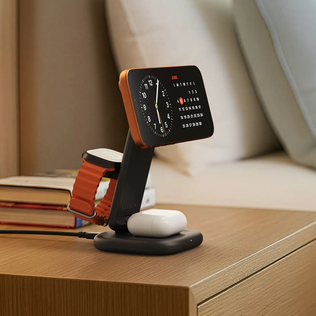 Satechi 3-in-1 Foldable Wireless Charging Stand with Qi2 25W on a nightstand, charging an iPhone, Apple Watch, and AirPods.