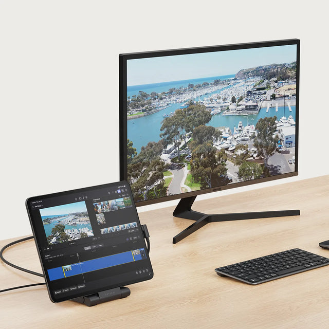 Satechi OntheGo™ Foldable Stand Hub connected to a tablet and an external monitor, displaying a dual‑screen workspace setup with video editing content on the tablet.