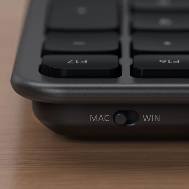 Close-up of a keyboard with MAC and WIN buttons on a wooden surface