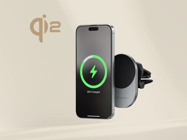 iPhone плавает рядом с беспроводным автомобильным зарядным устройством Satechi Qi2, установленным на вентиляционном отверстии автомобиля, и показывает уровень заряда 85%.