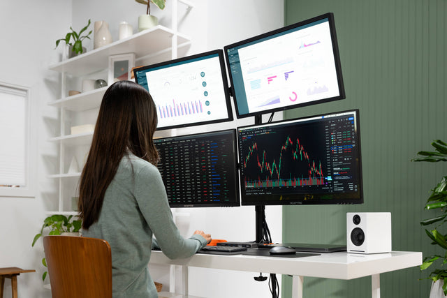 Person working at a desk with multiple computer monitors connected by the Thunderbolt 4 Docking Station with DisplayLink. 