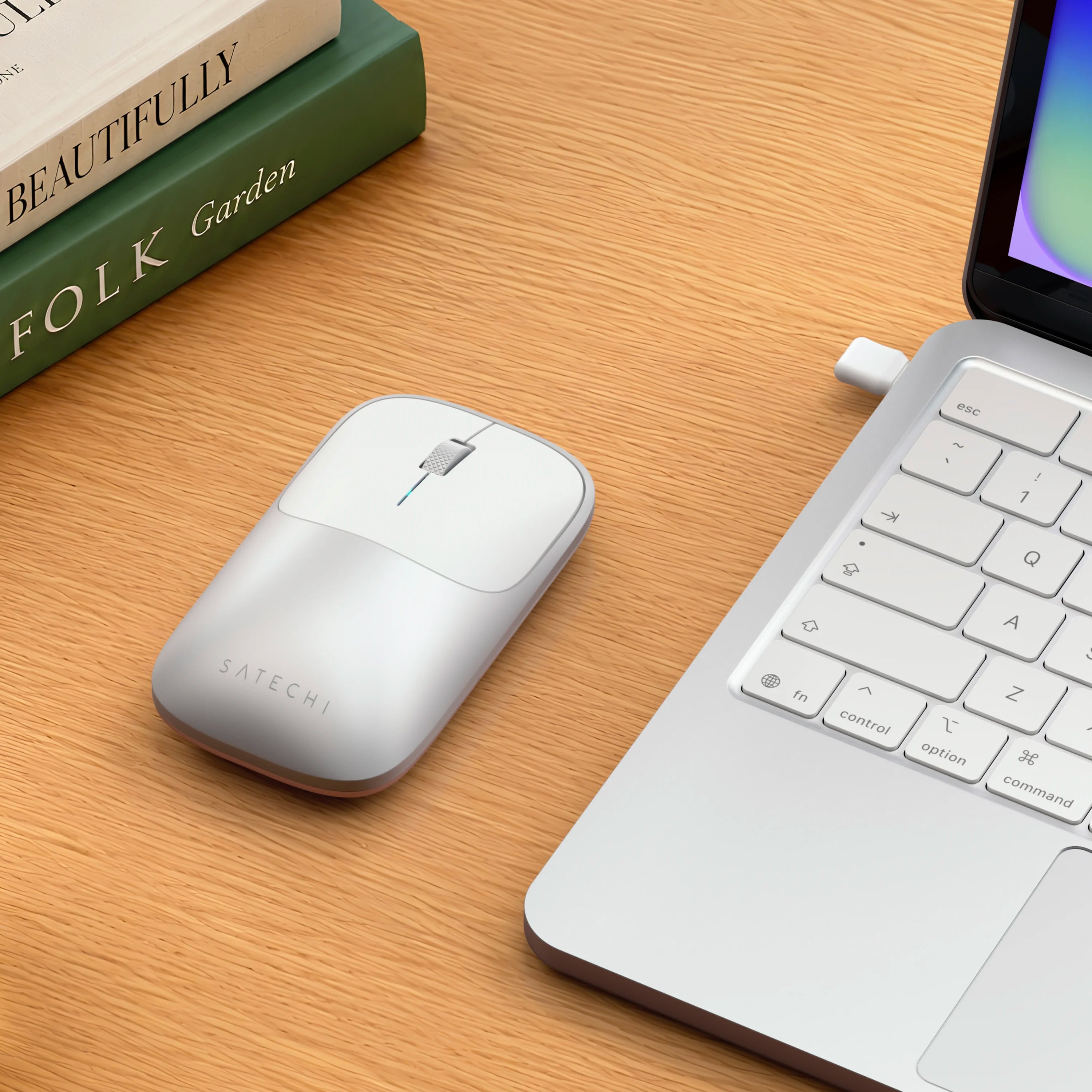 Satechi silver Slim EX Wireless Mouse on desk next to silver MacBook Neo.