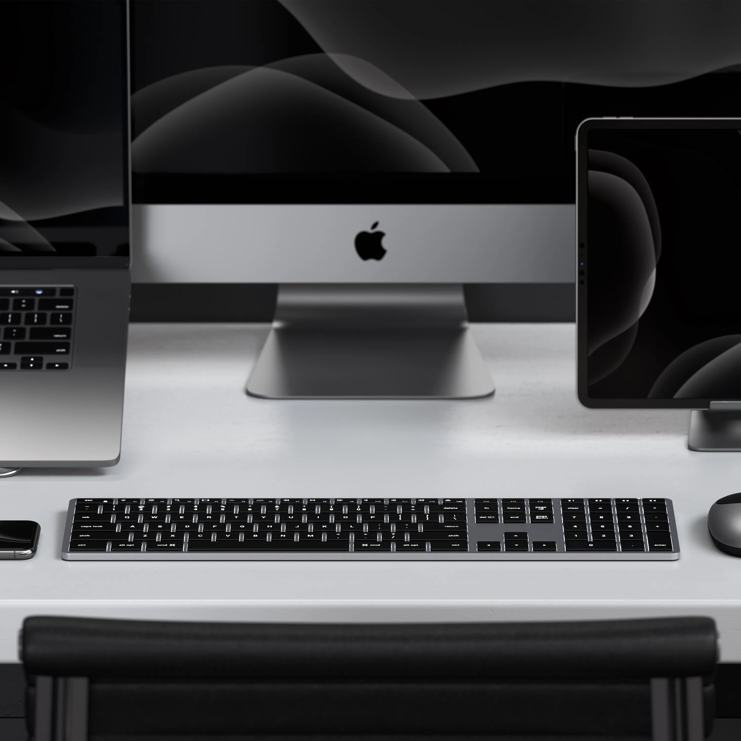 A Satechi Slim X3 Bluetooth Backlit Keyboard paired to a MacBook, iMac, and iPad.