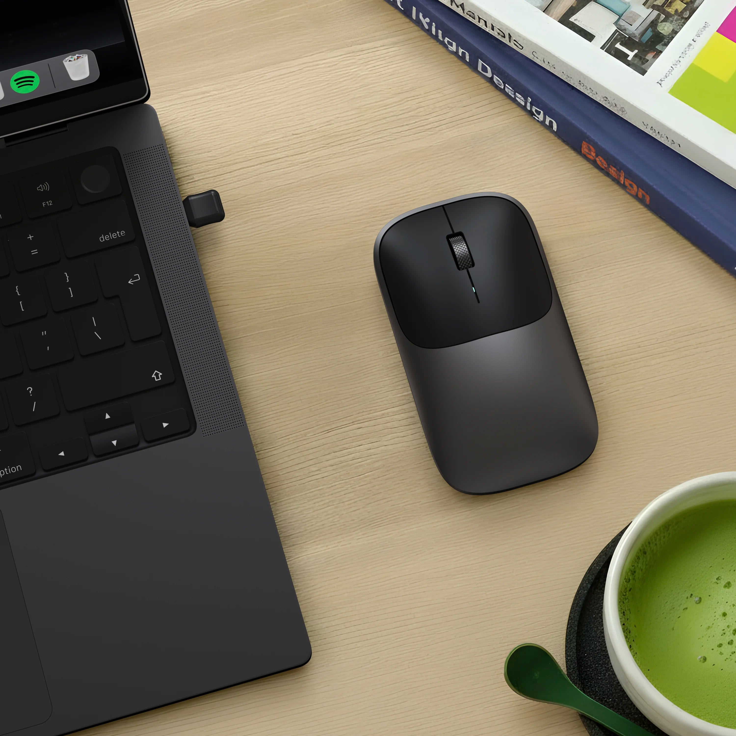 Satechi space black Slim EX Wireless Mouse on desk next to space black MacBook Pro.