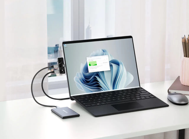 Satechi Mobile XR Hub cu audio conectat la un MacBook în timp ce utilizatorul navighează prin setările dispozitivului, demonstrând acces lin la fișiere și transfer rapid de date.